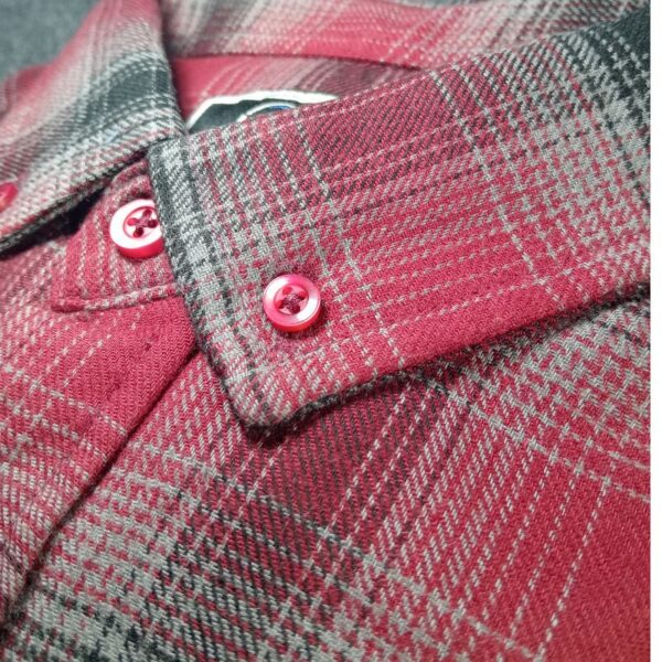 Close-up of the collar on a trendy red check shirt, highlighting its sharp tailoring, vibrant red checkered design, and slim-fit modern style.